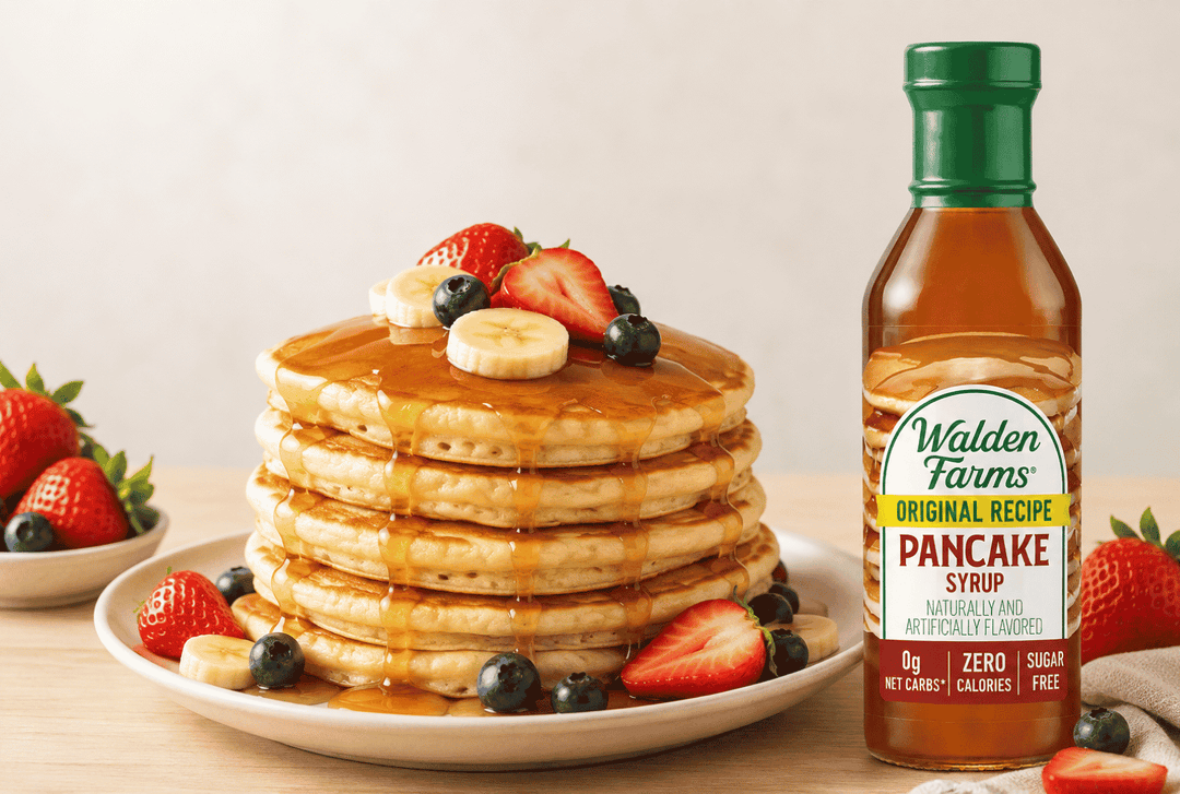 A bottle of Walden Farms Original Recipe Pancake Dressing beside a stack of pancakes topped with syrup and fruit